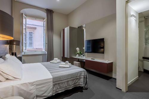 a hotel room with a bed and a television at Salina Luxury Suites in Parma