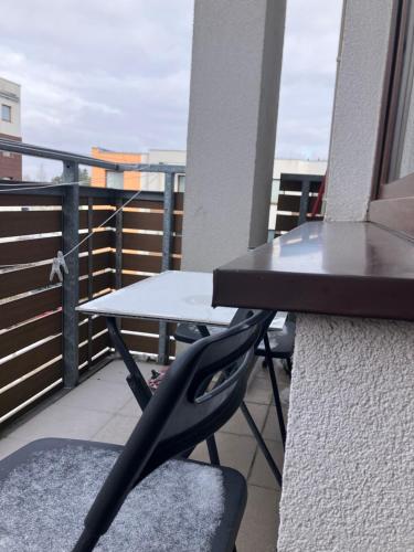a table and a chair on a balcony at Szybowników 2 in Piła