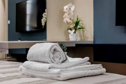 a pile of towels sitting on top of a bed at Salina Luxury Suites in Parma