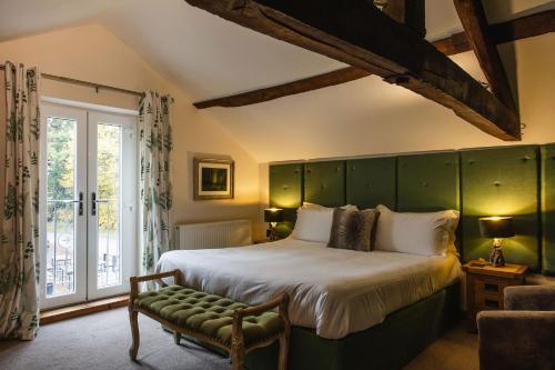 a bedroom with a large bed with a green headboard at The Haughmond in Shrewsbury