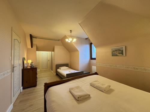a bedroom with a bed with two towels on it at La Changéenne - Maison de charme - 12 pers in Changé