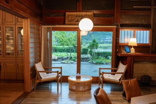 a room with two chairs and a table and a window at 囲宿-Kakomiyado- in Eiheiji