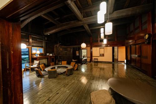 a large living room with wooden floors and wooden ceilings at 囲宿-Kakomiyado- in Eiheiji