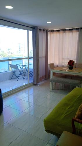 a living room with a table and a balcony at Cartagena Sotavento Laguito in Cartagena de Indias