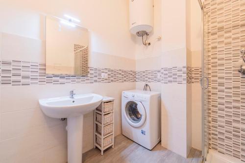 a bathroom with a sink and a washing machine at Monolocale Giulio Cesare in Novara