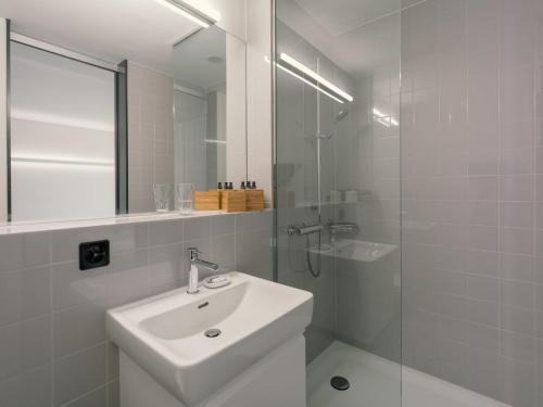 a white bathroom with a sink and a shower at b20 - serviced apartments bern ag in Bern