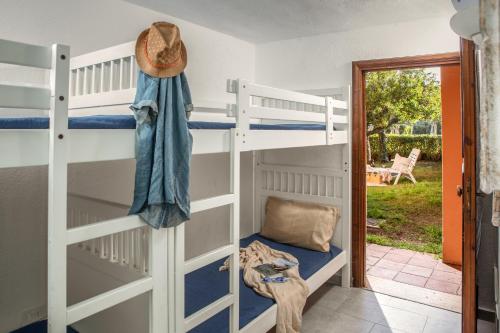 a bedroom with bunk beds and a door to a yard at Ampio Trilocale sul Golfo di Marinella in Santa Marinella