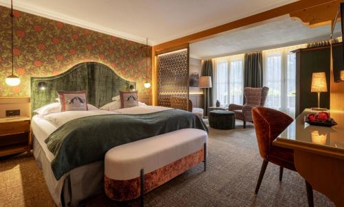 a hotel room with a bed and a desk at Romantik Hotel Schweizerhof in Grindelwald