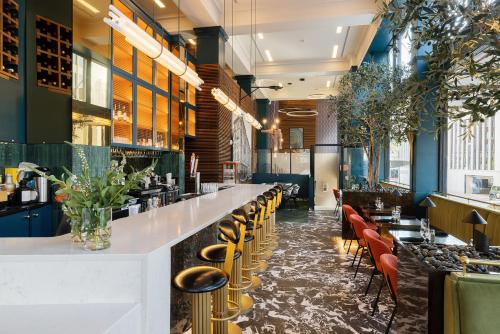 a restaurant with a bar with yellow stools at voco Hotel Napoleon Memphis by IHG in Memphis