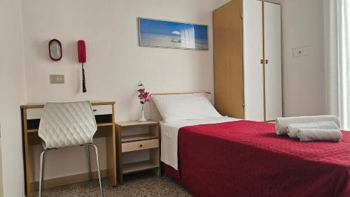 a bedroom with a bed and a desk and a chair at Hotel Bel Air Frontemare in Rimini
