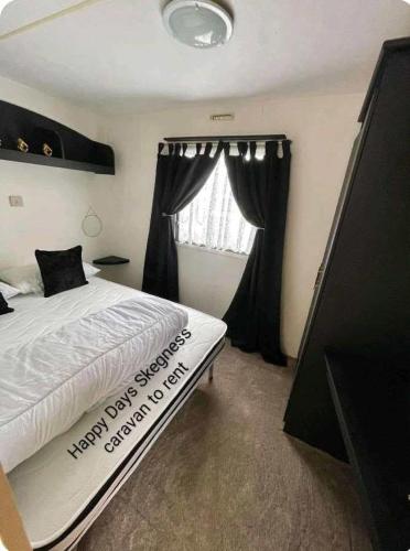 a bedroom with a large bed and a window at 6 berth static in Skegness in Chapel Saint Leonards