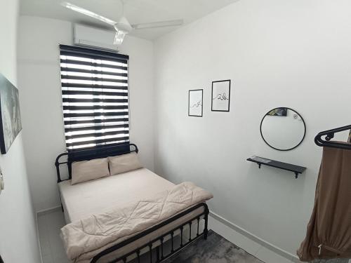 a small bed in a room with a window at Babah Homestay in Merlimau