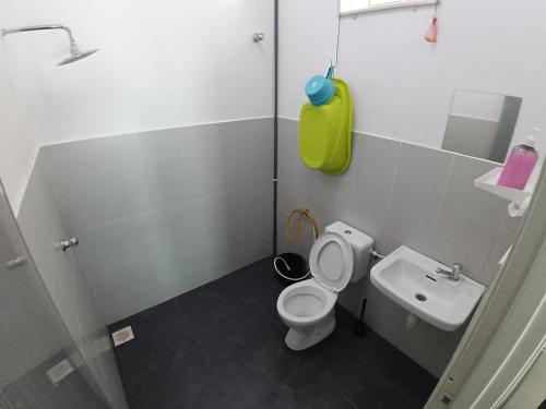 a bathroom with a toilet and a sink at Babah Homestay in Merlimau