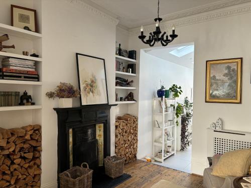 a living room with a fireplace and a chandelier at Cosy Victorian house with free parking & fireplace in London