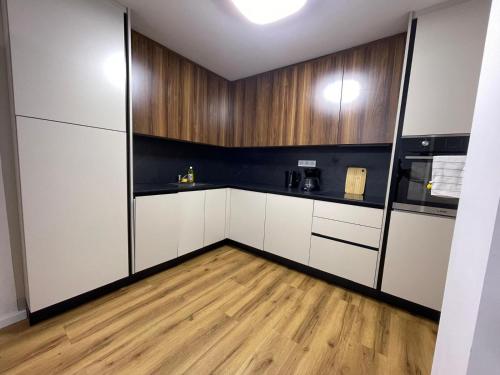 a kitchen with white cabinets and a wooden floor at Soltauer Bleibe in Soltau