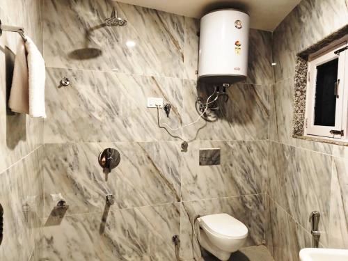 a bathroom with a toilet and a shower in it at Kashmir Beautiful Villa in Srinagar