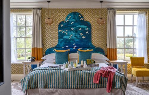 a bedroom with a large bed with a blue headboard at Seaham Hall and Serenity Spa in Seaham