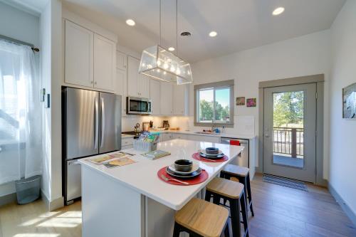 a kitchen with white cabinets and a kitchen island with chairs at Bozeman Home with Deck Walk to Fishing, Hot Springs in Bozeman