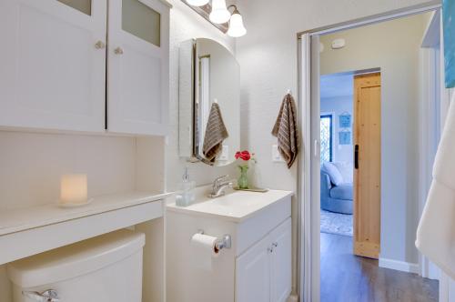 a white bathroom with a sink and a mirror at Lanai & Community Pool Access: Sunny Central Condo in Kailua-Kona