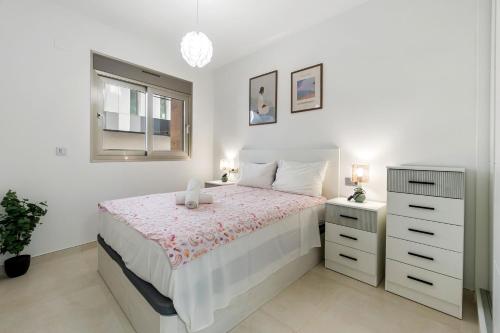 a bedroom with a bed and a dresser and a window at He Musica in Torrevieja