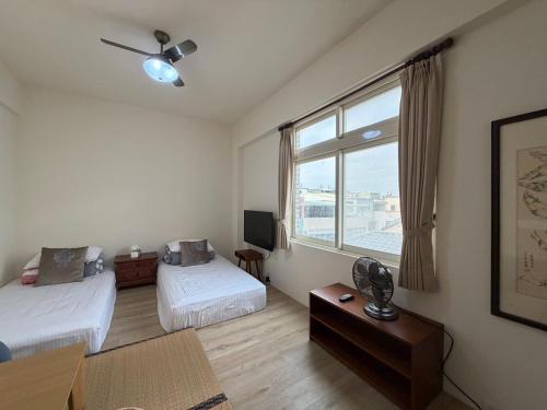 a hotel room with two beds and a window at Emerald Grange in Gongguan