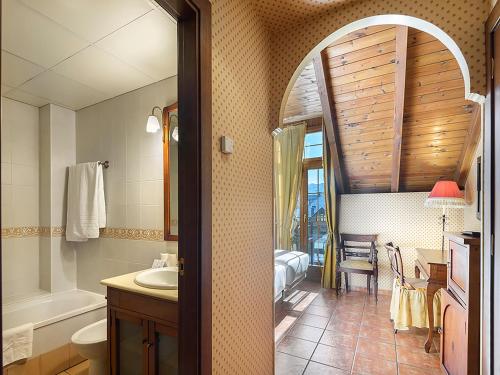 ein Badezimmer mit Waschbecken, Toilette und Badewanne in der Unterkunft Hotel Bocalé 3000 in Sallent de Gállego