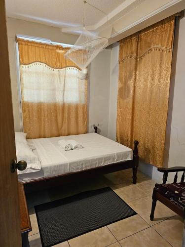 a small bed in a room with a window at Corosol Apartments in Roseau