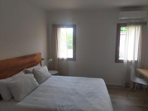 a bedroom with a large white bed and two windows at Ca' Rino - alloggio turistico in Vedelago