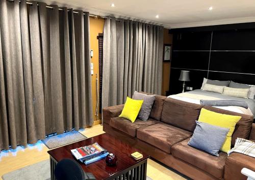 a living room with a couch and a bed at Urban Oasis Gaborone "Secure Quiet Luxury in the City" near the CBD in Gaborone