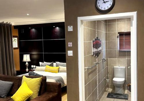 a bedroom with a bed and a clock on the wall at Urban Oasis Gaborone "Secure Quiet Luxury in the City" near the CBD in Gaborone