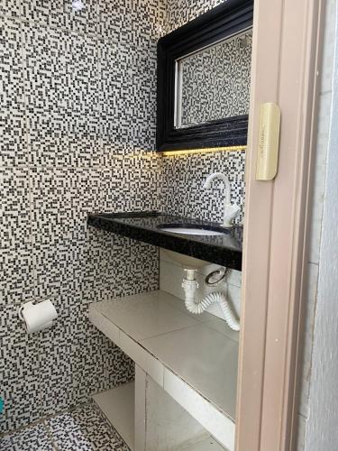 a bathroom with a sink and a mirror at Green duplex cottage in Camocim in Camocim