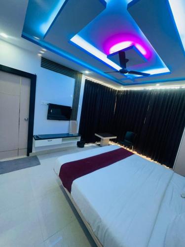 a bedroom with a large bed with a purple ceiling at Hotel Kunj Bihari in Lucknow