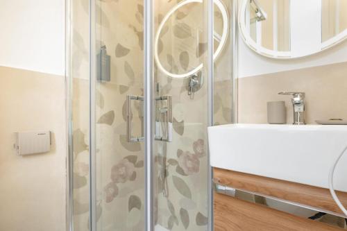 a shower with a glass door next to a sink at Hotel Victoria-Bike Friendly vicino Finalborgo e mare in Finale Ligure