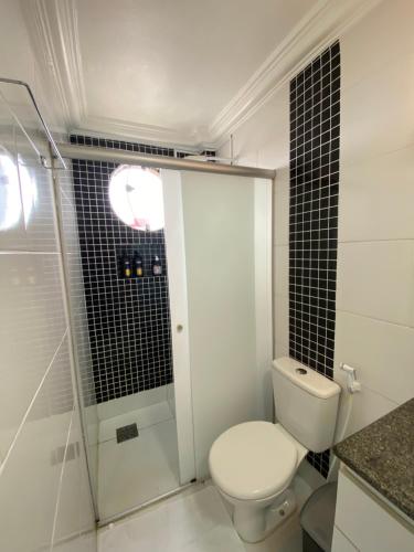 a bathroom with a toilet and a glass shower at Suíte Aconchegante in Belém