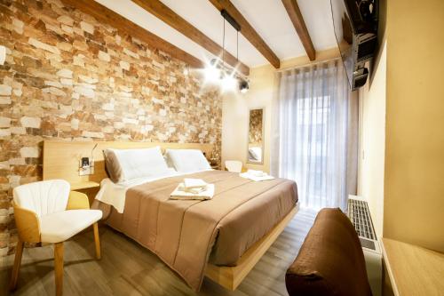 a bedroom with a large bed and a brick wall at Tzia Lillina B&B in Iglesias