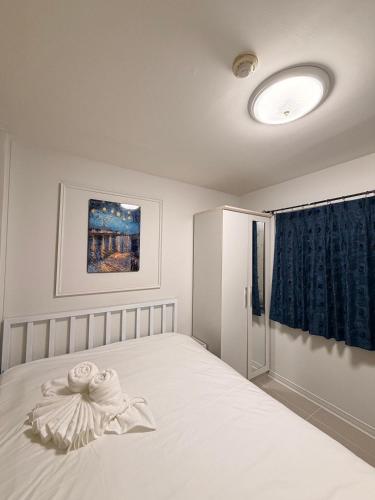 a bedroom with a white bed with a blue curtain at Best Value Condo Lumpini Rajamangala in Sathani Khlong Tan