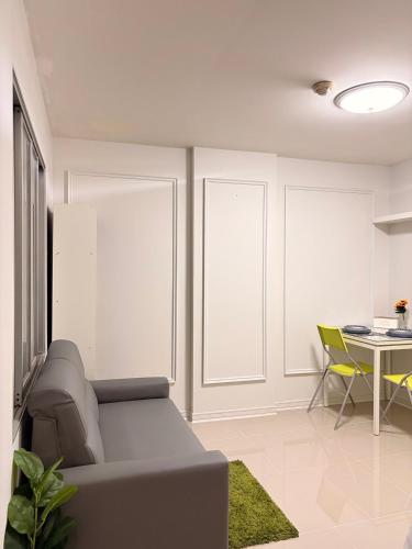 a living room with a couch and a table at Best Value Condo Lumpini Rajamangala in Sathani Khlong Tan