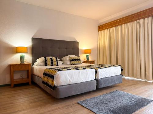 a bedroom with a large bed with two pillows at Luna Hotel da Oura in Albufeira