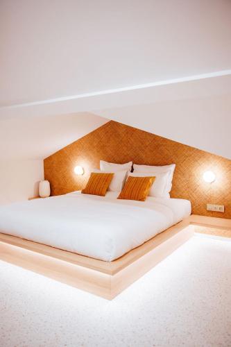 a bedroom with a large white bed with two pillows at Héritage Collection - Suites in Verviers