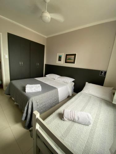a bedroom with two beds and a bench in it at Suíte Aconchegante in Belém