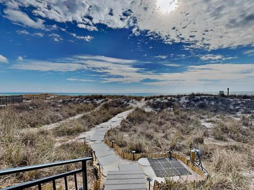 a boardwalk in the middle of a field with a sky at Tiki Tango Hideaway in Panama City Beach