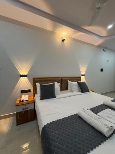 a bedroom with a large bed with two pillows at HOTEL FORTUNER Inn in Bangalore