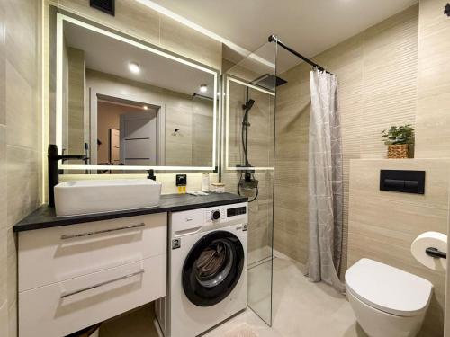 a bathroom with a washing machine and a sink at Fly Apartment Modlin by JumpInHere in Nowy Dwór Mazowiecki