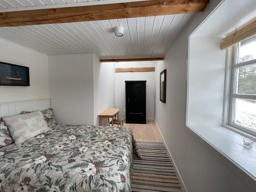 a bedroom with a bed and a window at Wildernest Bornholm - Hjorten in Neksø