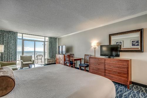 a hotel room with a bed and a flat screen tv at Dunes Village in Myrtle Beach