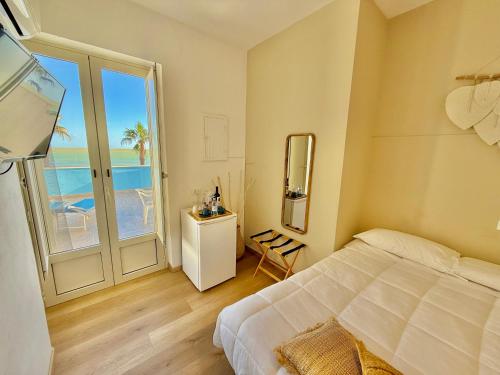 a bedroom with a bed and a view of the ocean at Terrazze Sul Mare in Pozzallo