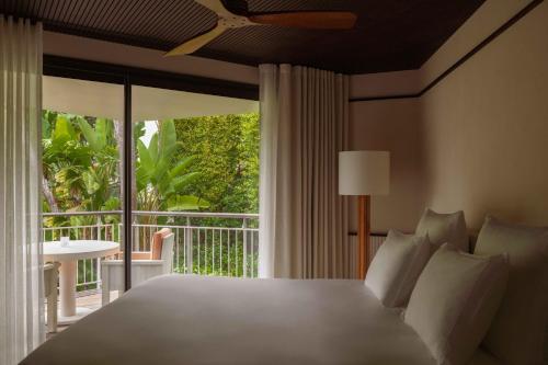 a bedroom with a large bed and a balcony at Cap d'Antibes Beach Hotel in Juan-les-Pins