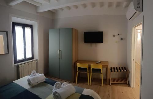 a bedroom with a bed and a table and a cabinet at La terrazza del Papa in Pienza
