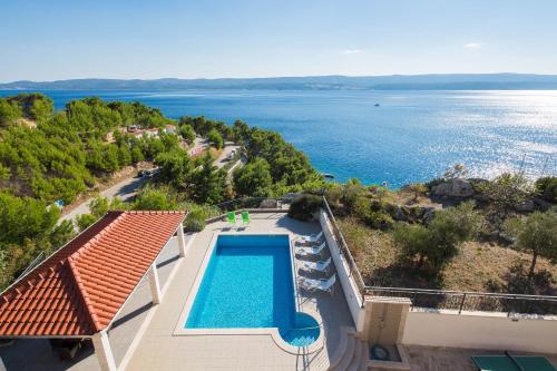 an aerial view of a swimming pool and the ocean at Beachfront Apartments Lara in Omiš