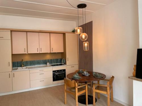 a kitchen with a table and chairs and a kitchen with white cabinets at 'Lima' Luxe appartement in Vlissingen in Vlissingen